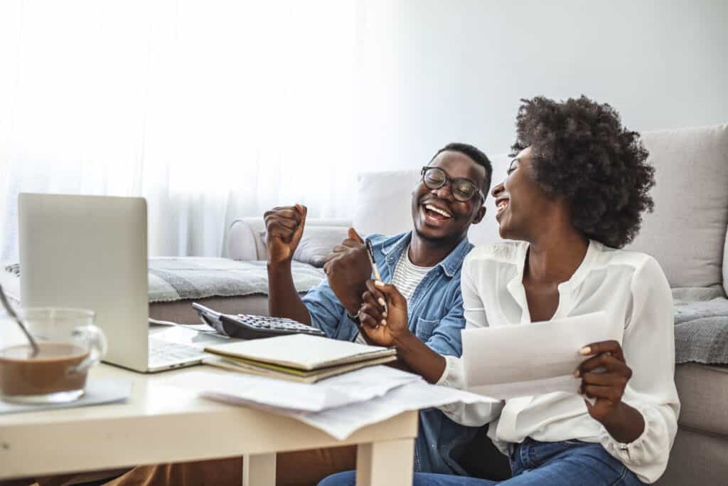 Happy couple with laptop spending time together at home.